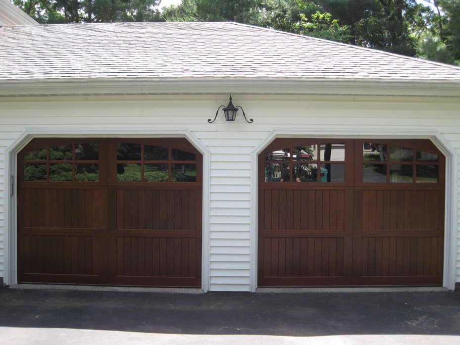 Pair of dark wood garage doors on a white building